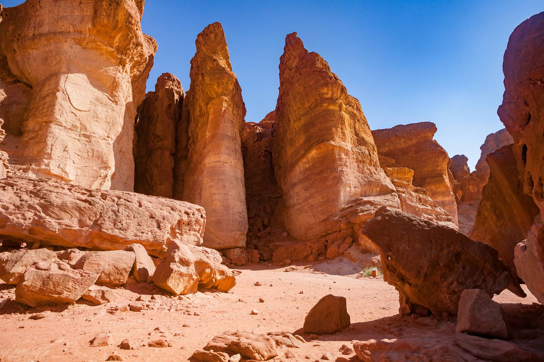 Towering sandstone formations in a desert landscape with a clear blue sky.